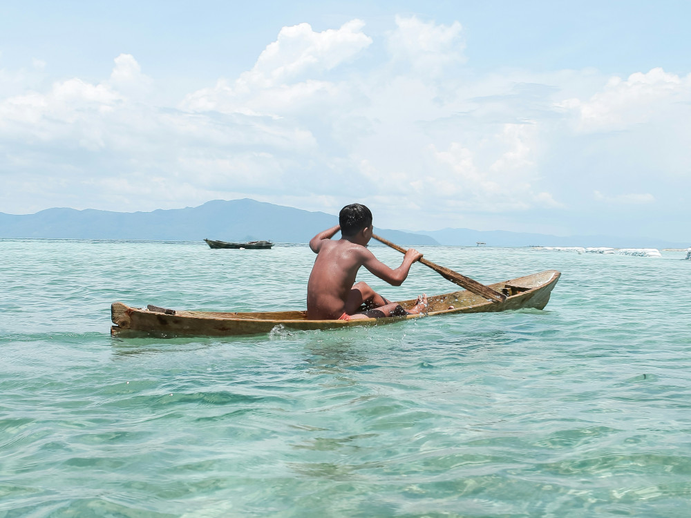 Kind in een traditioneel bootje, Oost-Indonesië - Undiscovered.nl