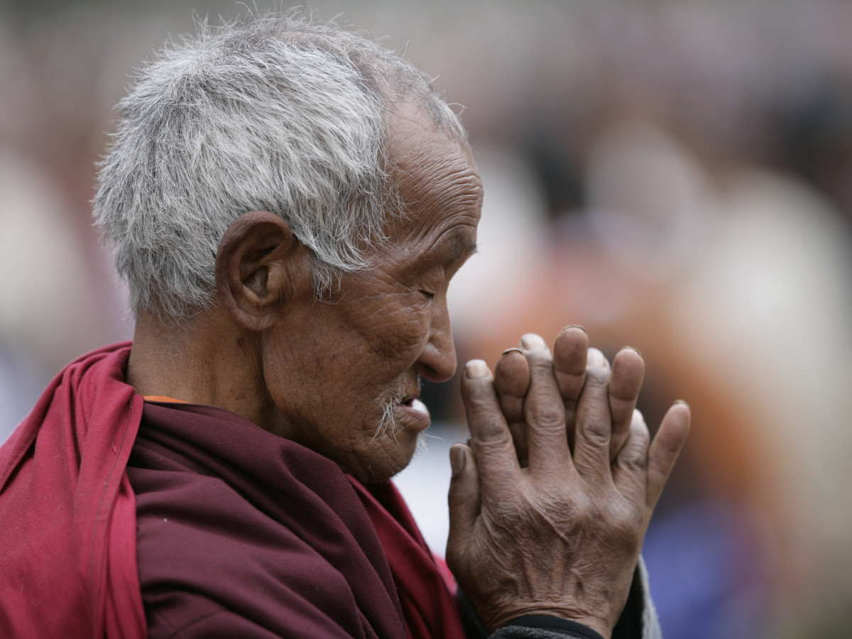 Biddende man in Bhutan - Undiscovered.nl