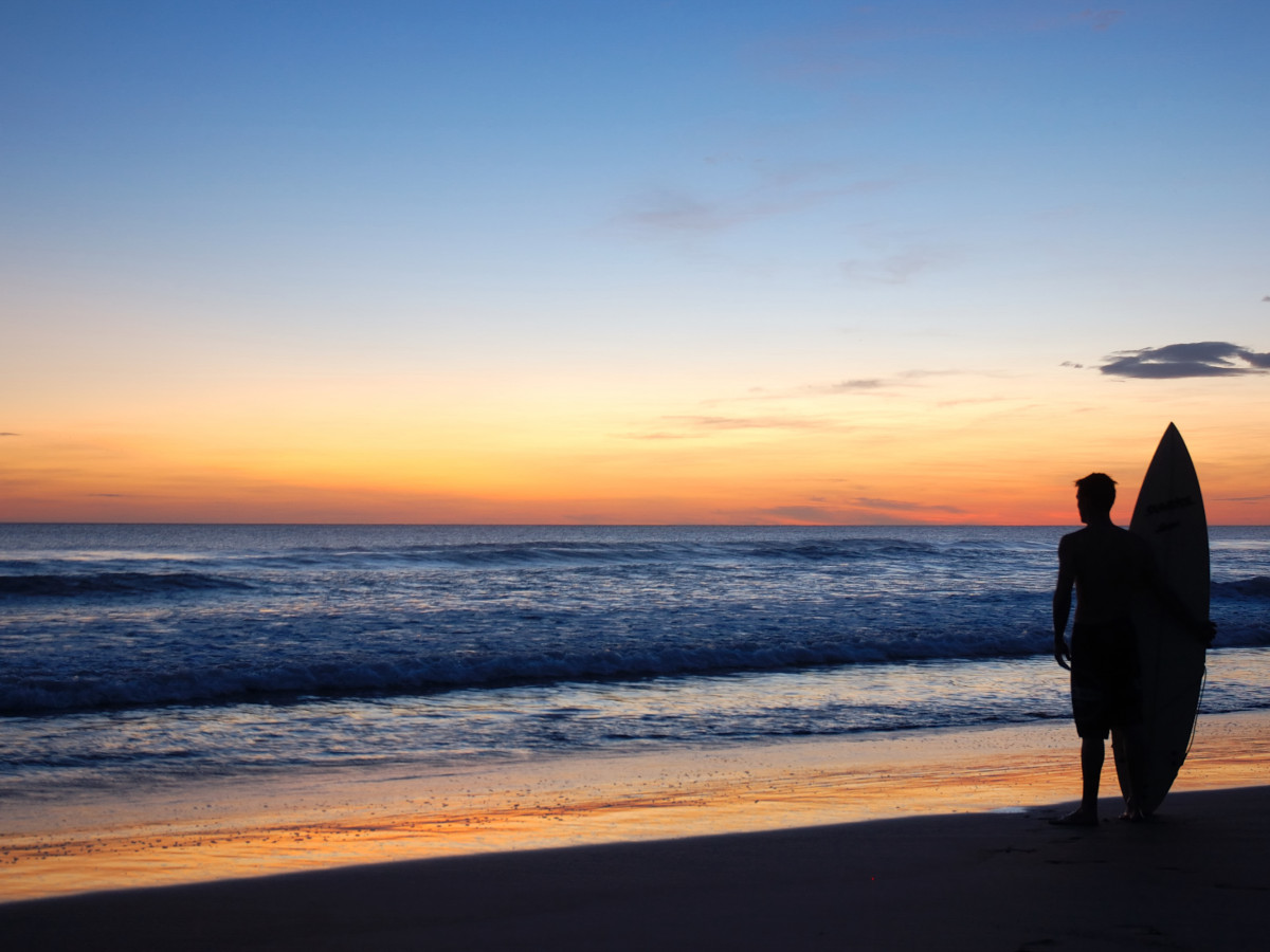 Surfer met zonsondergang in Nicaragua - Undiscovered.nl